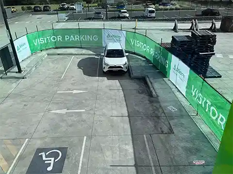 Shade cloth signage fitted to a curved car park fence
