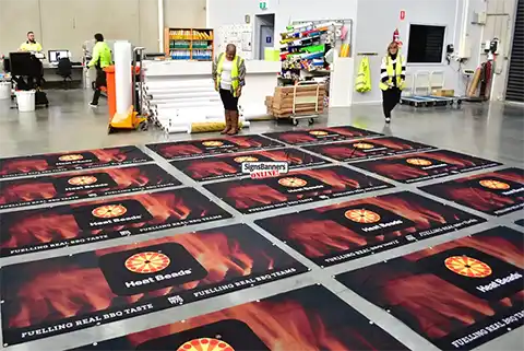This image in the printing sign factory shows multiples of banner and team members busy in our Australian factory making signs.