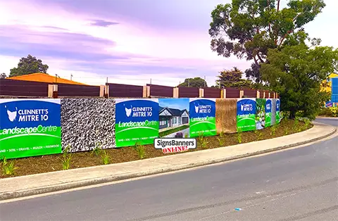 This image at twilight shows a printed vinyl hoarding banner on the hardware supplies garden area fencing.