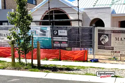 This photo in Oran Park shows individual Tradie Banners fitted to a construction site fence panels with concrete blocks.