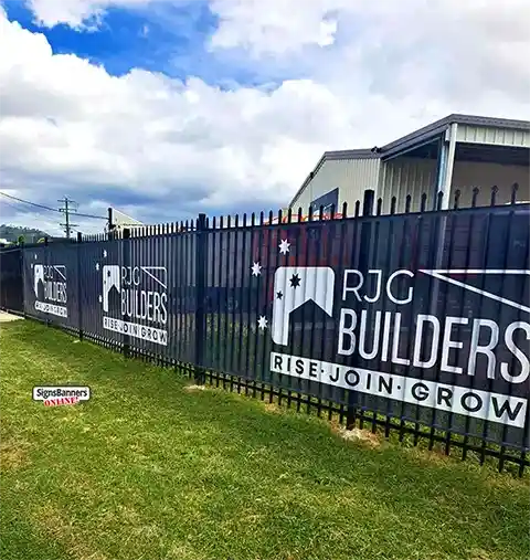 Banner fixed to a powder-coated metal fence using stainless steel eyelets for strong, reliable fastening.