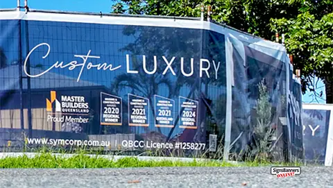 This fence sign in Bundall Queensland shows lots of awards and promotes the building company services wrapping around the worksite.
