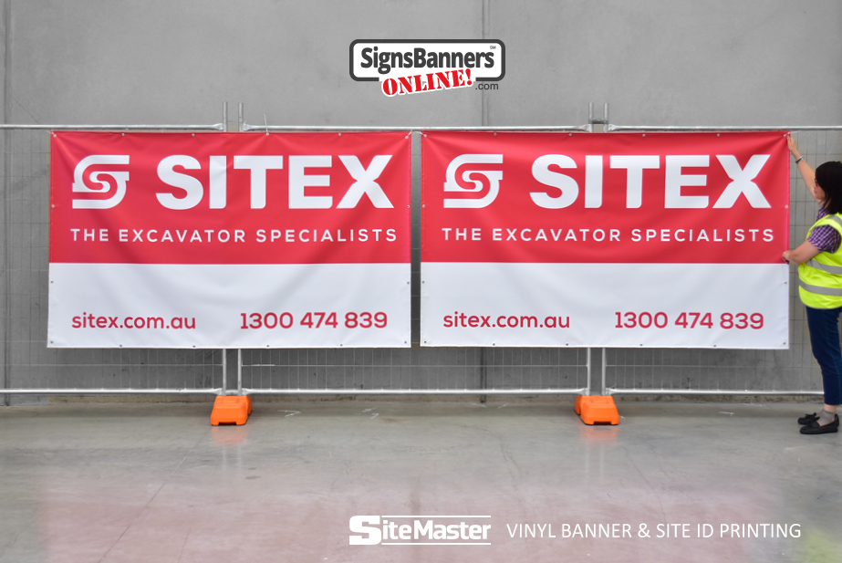 Two matching red and white Sitex excavator specialist vinyl banners mounted on temporary fencing, with a worker adjusting one.