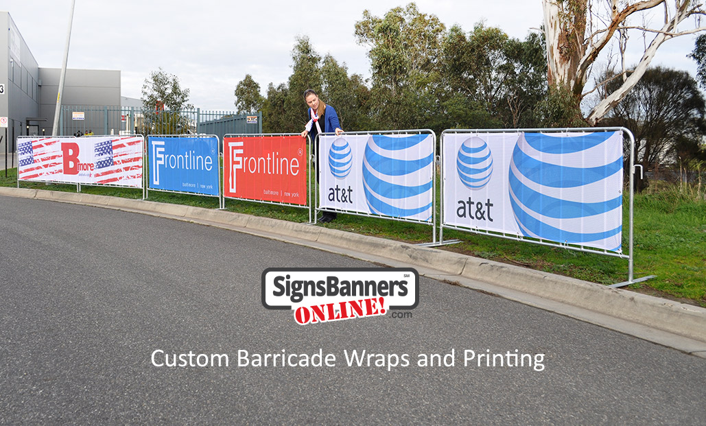 Custom barricade wraps (banner signs fitted to crowd control fence systems) set up on the street ready for an event